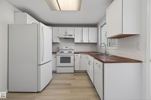 Kitchen featuring white cabinetry, wood-finish countertops, and light wood-finish flooring - 156 Lee Ridge Road, Edmonton, AB - Indoor Photo Showing Kitchen With Double Sink