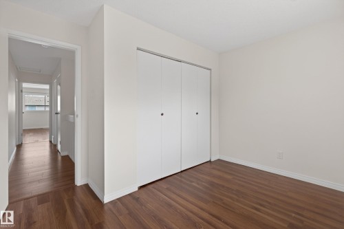 Room featuring wood-finish flooring, white walls, and a large bi-fold closet - 156 Lee Ridge Road, Edmonton, AB - Indoor Photo Showing Other Room