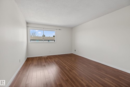 Bright interior space featuring wood-finish flooring, white baseboards, and neutral wall paint - 156 Lee Ridge Road, Edmonton, AB - Indoor Photo Showing Other Room