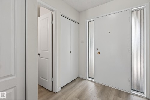 Entryway featuring a white main door with two fluted glass sidelights, complemented by wood-finish flooring - 156 Lee Ridge Road, Edmonton, AB - Indoor Photo Showing Other Room