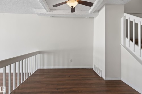 Open loft area featuring wood-finish flooring, a white spindle railing, and a ceiling fan with light - 156 Lee Ridge Road, Edmonton, AB - Indoor Photo Showing Other Room