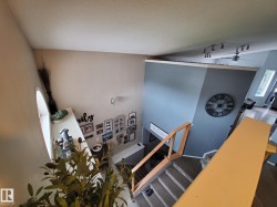 Multi-level interior featuring a vaulted ceiling and a round-top window - 