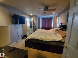 Carpeted room featuring a ceiling fan with integrated lighting, recessed ceiling lights, and bay windows - 