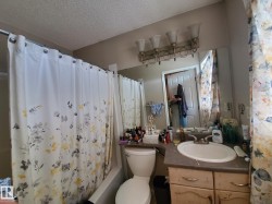Bathroom featuring a combination shower and tub, integrated vanity sink, and a four-light vanity fixture - 