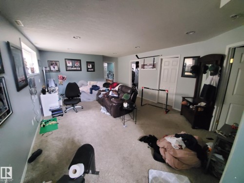 Carpeted room featuring light blue walls, recessed lighting, and a white paneled door - 53 Langley, Spruce Grove, AB 