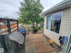 Multi-level wood deck featuring a slatted privacy fence with string lighting - 