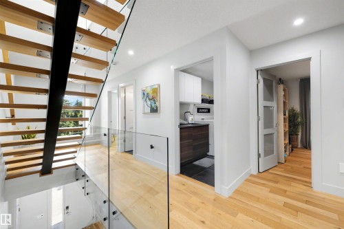 Stunning solid wood stairs accessing top floor area with rooftop patio, wet bar and entertaining area. - 7814 142 Street, Edmonton, AB 