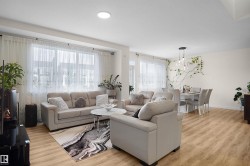 Open-concept living and dining areas featuring light wood-finish flooring - 