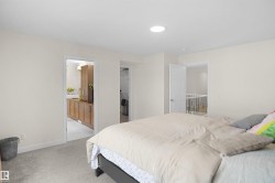 Bedroom with light gray carpeting, a circular ceiling light fixture, and white painted walls - 