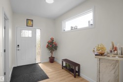Entryway featuring wood-finish flooring, a white paneled door with frosted glass inserts, and a sidelight with textured glass - 