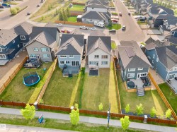 Rear exterior featuring a two-story design with a dark gray facade, expansive yard, and a multi-level deck - 