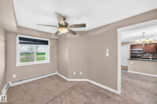 Carpeted room with a ceiling fan light fixture and window with blinds - 308 18126 77 Street, Edmonton, AB 