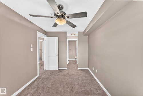 Room featuring textured carpeting, neutral wall paint, and white trim - 308 18126 77 Street, Edmonton, AB 
