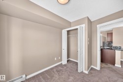 Carpeted room with neutral-toned walls, featuring a bi-fold door closet with wire shelving - 