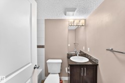 Bathroom featuring a dark wood-finish vanity with a white oval sink and a dark countertop - 
