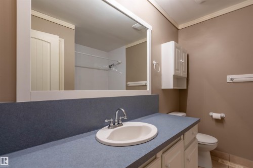 Bathroom vanity featuring a light blue countertop, an undermount sink, and a chrome faucet - 3 Glenforest Crescent, Stony Plain, AB 