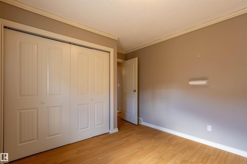 Room featuring wood-finish flooring, painted walls, crown molding, and baseboards - 3 Glenforest Crescent, Stony Plain, AB 