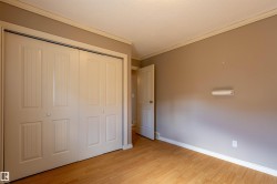 Room featuring wood-finish flooring, painted walls, crown molding, and baseboards - 