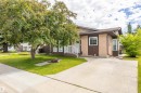 Contemporary exterior featuring two-tone stucco siding, white window frames, an angled roofline, and a concrete driveway - 3 Glenforest Crescent, Stony Plain, AB 