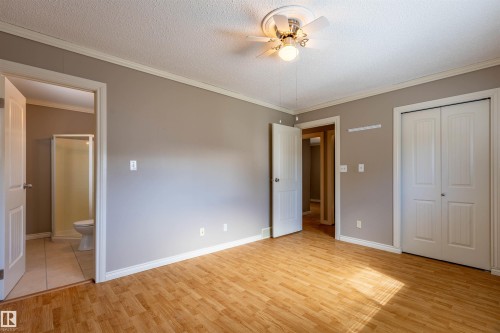 Spacious room featuring wood-finish flooring, neutral-toned walls, and white trim - 3 Glenforest Crescent, Stony Plain, AB 