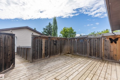 Spacious wood-finish deck area featuring privacy fencing and a dedicated access point to the structure - 3 Glenforest Crescent, Stony Plain, AB 