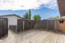 Spacious wood-finish deck area featuring privacy fencing and a dedicated access point to the structure - 