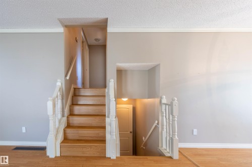 Wood-finish staircase with white balusters and handrails - 3 Glenforest Crescent, Stony Plain, AB 