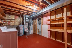 Utility room with exposed ceiling joists and red flooring - 