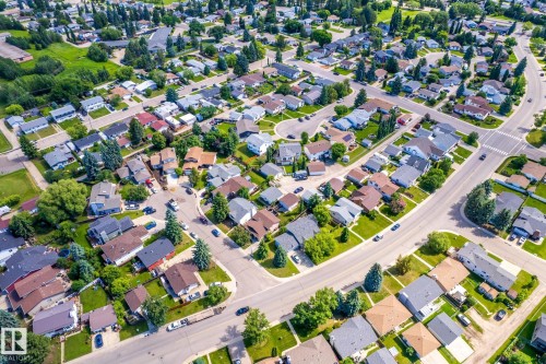Aerial overview of a residential neighborhood with a diverse mix of single-story and multi-story homes, established landscaping, paved streets, and a grid-like street layout - 3 Glenforest Crescent, Stony Plain, AB 