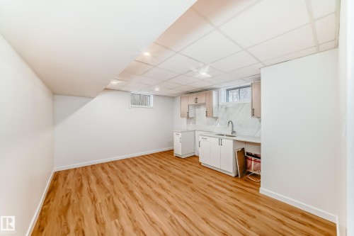 Finished basement space featuring wood-finish flooring, white walls, and recessed lighting - 4842 116Ave, Edmonton, AB - Indoor Photo Showing Other Room