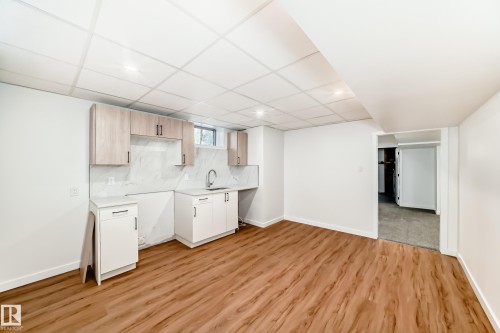 Spacious open area featuring wood-finish flooring, recessed lighting, and a drop ceiling - 4842 116Ave, Edmonton, AB - Indoor Photo Showing Kitchen