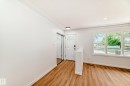 Bright entryway featuring wood-finish flooring, a white front door with decorative glass, and a mirrored sliding closet door - 4842 116Ave, Edmonton, AB  - Indoor Photo Showing Other Room 