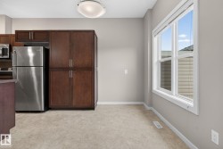 Kitchen dining area featuring a prominent window, neutral wall color, and light-toned flooring - 