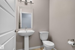 Pedestal sink with chrome faucet, rectangular mirror, and a three-light vanity fixture - 
