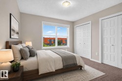 Carpeted bedroom with a large window and two sets of bifold closet doors - 