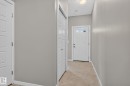 Bright interior hallway featuring light gray walls and beige carpeting - 57 3710 Allan Drive, Edmonton, AB 