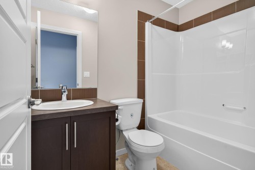 Bathroom with a white bath and shower combination unit - 57 3710 Allan Drive, Edmonton, AB 