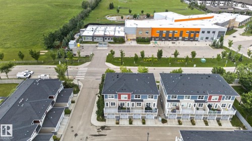 Aerial perspective highlighting multi-story townhomes with individual garage bays and balconies - 57 3710 Allan Drive, Edmonton, AB 
