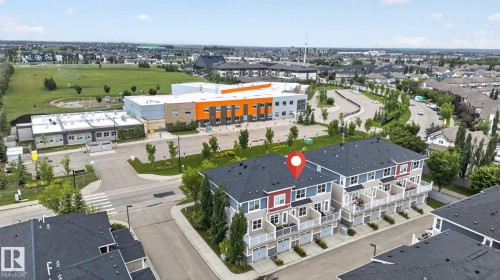 Townhouse row featuring multi-level facades, individual balconies, and ground-level garages - 57 3710 Allan Drive, Edmonton, AB 