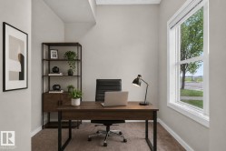 Dedicated office space featuring a large window, neutral wall paint, and carpeted flooring - 