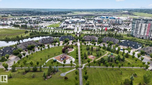 Aerial perspective highlighting residential properties bordering a central green space with walking paths and two distinct playground areas - 57 3710 Allan Drive, Edmonton, AB 