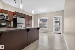 Modern kitchen featuring dark wood cabinetry, stainless steel appliances, and an integrated double basin sink - 