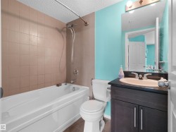 Full bathroom featuring a white tub, shower with chrome fixtures, and tiled surround - 