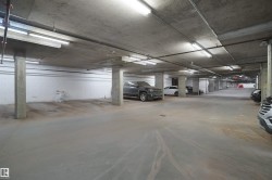 Concrete underground parking garage featuring multiple parking spaces - 