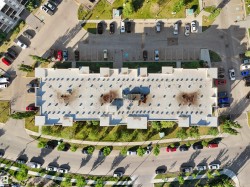 Multi-unit residential structure featuring a flat roof and surrounding paved parking areas - 