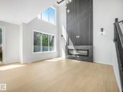 Spacious room featuring a contemporary linear fireplace with a dark stone-finish surround - 