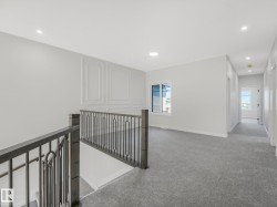 Upper level landing featuring gray carpeting and white walls - 