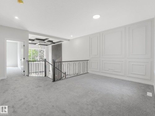 Upper-level landing featuring light gray carpeting, a decorative paneled accent wall, and recessed lighting - 1717 Crossbill Loop, Edmonton, AB - Indoor Photo Showing Other Room