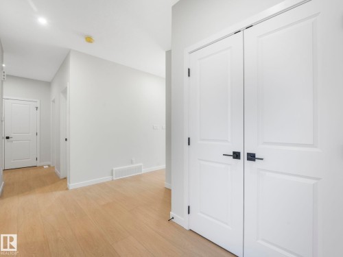 Hallway featuring light wood-finish flooring, white walls, and bright overhead lighting - 1717 Crossbill Loop, Edmonton, AB - Indoor Photo Showing Other Room