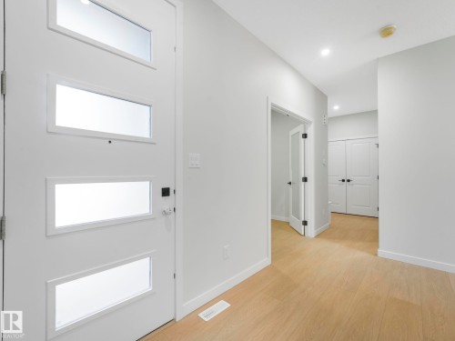 Contemporary entry door featuring three horizontal frosted glass panels and modern black hardware - 1717 Crossbill Loop, Edmonton, AB - Indoor Photo Showing Other Room